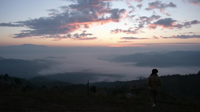 A woman walking to see a beautiful sea of fog and mountain views before sunrise