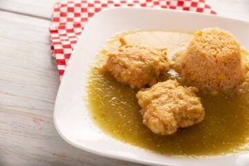 Cutlets of shredded chicken meat fried in batter egg, in Mexico known as Tortitas de Pollo, bathed with green sauce and accompanied by rice. Traditional and very popular homemade recipe in Mexico.