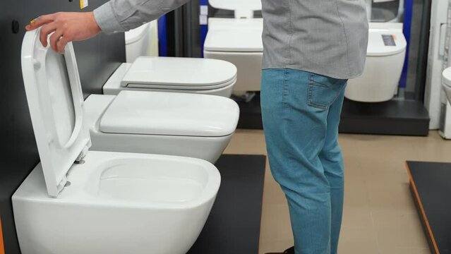 A man choosing home toilet in store
