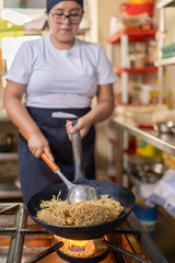 Professional peruvian chef preparing noddles in a restaurant