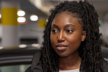 This image captures a young woman in a moment of reflection, her gaze directed off-camera to an...