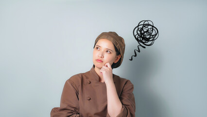 落ち込む調理服を着た女性
