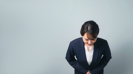 お辞儀するスーツを着た女性