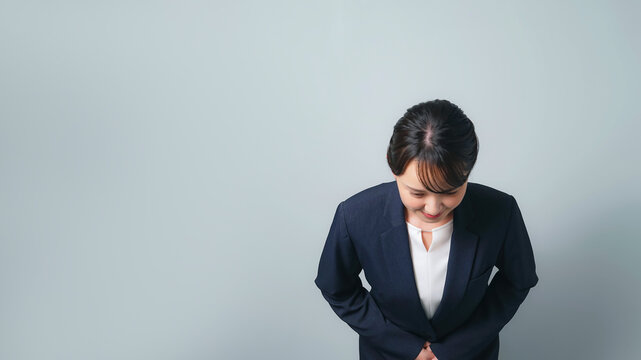 お辞儀するスーツを着た女性