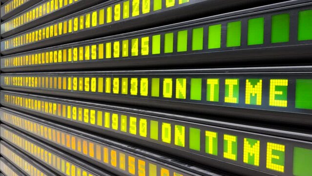 Digital board with yellow led letters and numbers on green illuminated squares, electronic display in airport terminal showing real-time flight information. High quality 4k footage
