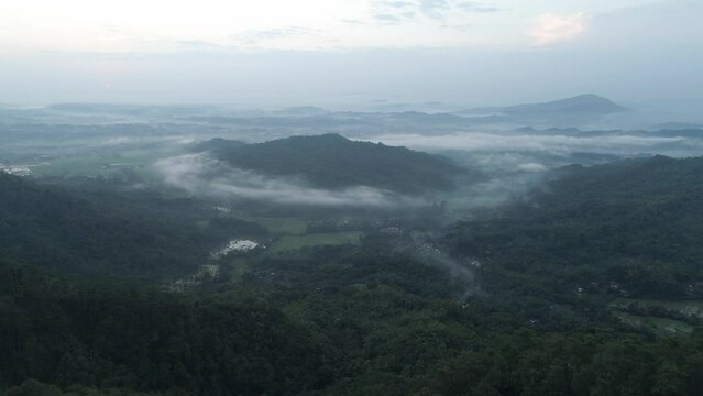 aerial footage beautiful view of hills and mountains in a cloudy morning in Banyumas, Central Java, Indonesia 4K Drone | Sawah berselimutkan awan di pagi hari