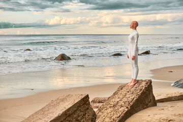Full length portrait of young hairless girl with alopecia in white futuristic suit standing on...