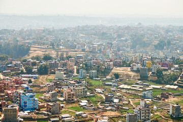 Fototapeta na wymiar View of Kathmandu capital of Nepal from mountain through urban haze with lot of low rise buildings, cityscape creating an ethereal atmosphere in mountain air, Kathmandu air pollution