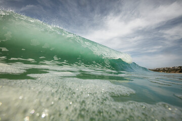 View of a wave from the water with the crest curling over.