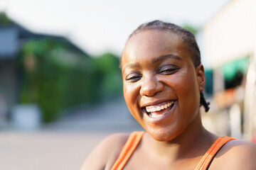 Happy beautiful American - African black ethnicity woman smiling and laughing to camera.