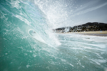 View of a wave from the water with the crest curling over.