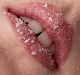 Close-up of a girl's lips in lipstick with snowflakes. Macro