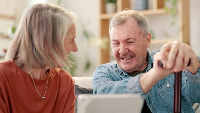 Tablet, funny and senior couple laughing at joke, comedy and relax in home living room together. Technology, man and woman watch meme on social media app online, happy and retirement conversation