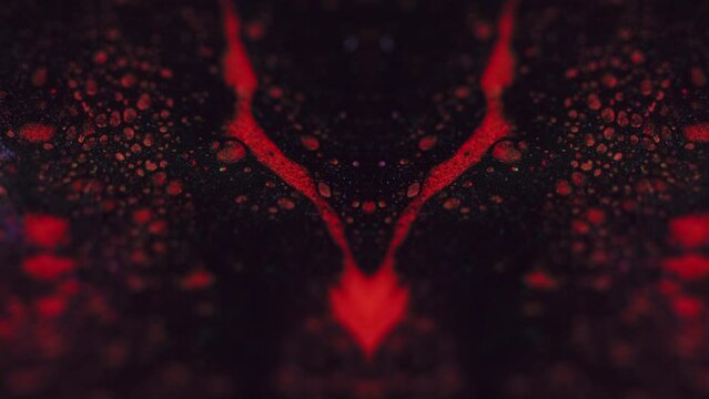 Paint spill. Ink kaleidoscope. Defocused red black color bubble texture fluid drip flow motion symmetrical ornament on dark abstract art background.
