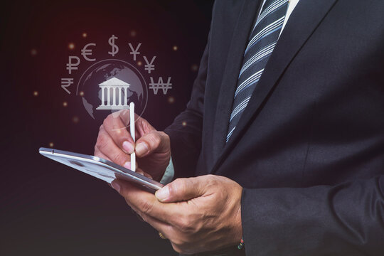 Global Businessman and Global currency exchange concept, money, transfer, finance, Businessman holding tablet with virtual world map and dollar yuan yen euro ruble rupees and pound sterling sign.