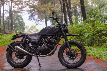 Naklejka premium motorcycle on the road in the middle of the forest