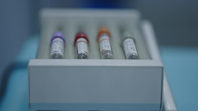 Medical blood test tubes in various colors organized in a laboratory rack. Chemical and medical research. Laboratory test. Medical equipment. Health care