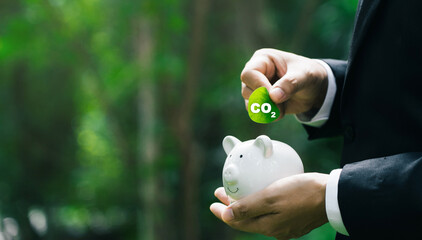 Carbon credit concept with businessman holding leaf green globe reducing saving carbon emissions carbon neutral concept. - 717525309
