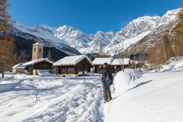Hiker on vacation photographs a scenic winter landscape with snow in european Alps. Wonderful...
