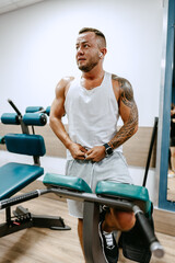 Man bodybuilder in white shirt training in a gym