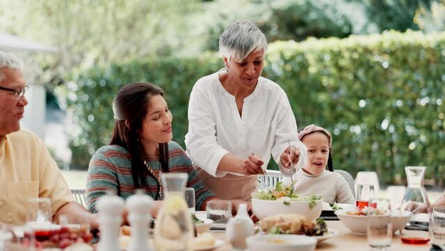 Food, outdoor and grandparents with big family or child at table in thanksgiving celebration or tradition. Salad, share or lunch with people, grandma or kid eating meal together in a social gathering