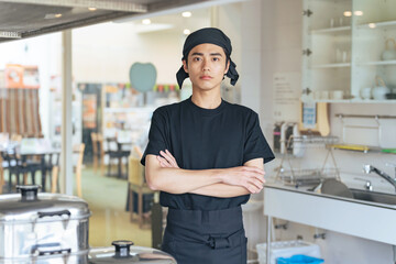 厨房で腕組みする男性調理師