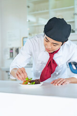 デザートを盛り付けるパティシエ