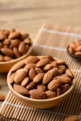 Raw almond nut in bowl on wooden background