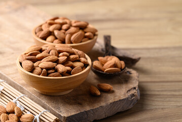Raw almond nut in bowl on wooden background