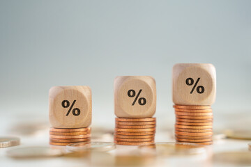 Business and financial growth, Interest rates increase, Inflation, Sale price, budget and tax rise concept. Wooden block with percentage sign on growing of stack of money coins.
