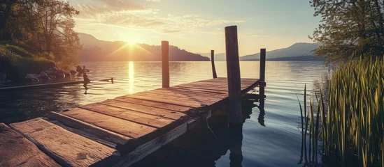  landscape of a lake at sunset and with a wooden jetty. Copy space image. Place for adding text or design © Gular