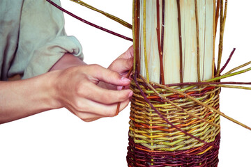 Men's hands for weaving handmade baskets, isolated on a white background. Products from twigs in a...