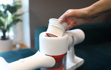 Hand takes filter out vacuum cleaner in apartment. Filter bandwidth. High-quality housing with...