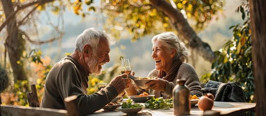 Fotobehang Healthiness and happiness go hand in hand Shot of a happy older couple enjoying a healthy lunch together outdoors. Copy space image. Place for adding text or design © Gular