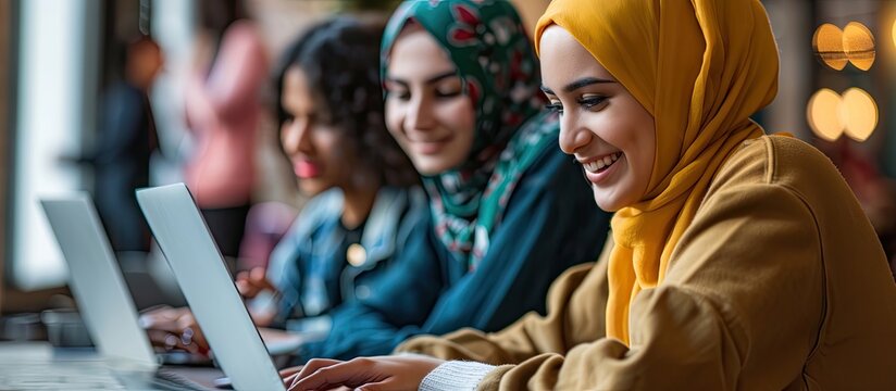 Happy Middle Eastern female student talking to her friends while using laptop and studying together. Copy space image. Place for adding text or design