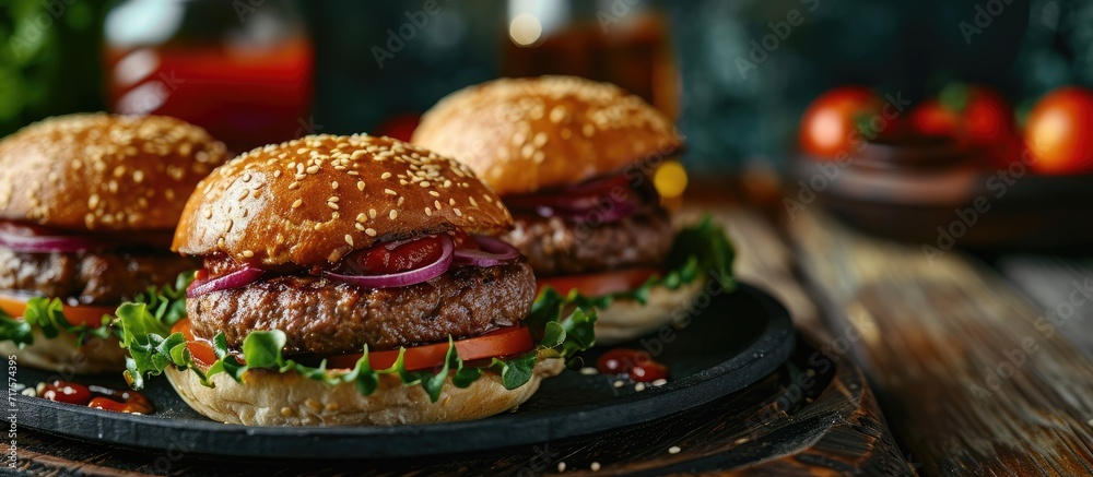 Poster homemade hamburger grilled beef patties sesame buns with other ingredients on dark slate plate. copy
