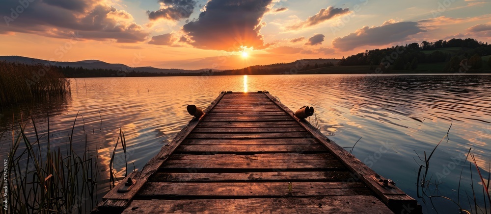 Poster landscape of a lake at sunset and with a wooden jetty. Copy space image. Place for adding text or design