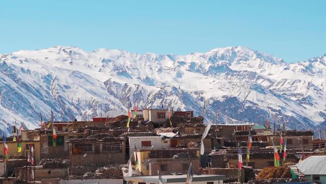 Nako Village in front of snow covered Himalayan mountain peaks as seen on the way to Spiti Valley in Himachal Pradesh, India. Beautiful mountain village in the Himalayas in winter season in India.
