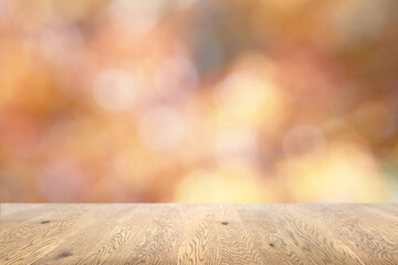 玉ボケでキラキラ輝く背景で木目のある木のテーブルの背景画像