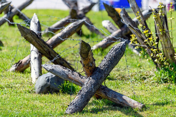 Military obstacles, wood anti tank hedgehoges on the field. Constructions protecting freedom.