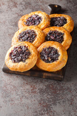 Cebularz Lubelski Polish round flatbread with red onion and poppy seeds close-up on a wooden board on the table. Vertical