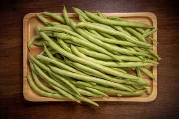 Green bean or Green pea in wooden plate on wooden background, French Bean or Green bean in wooden basket on wooden table.