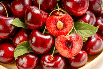 Close up shot Red Cherry on wooden background, Red Cherry fruit in wooden basket on wooden table.
