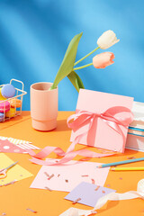 Festive birthday ambiance featuring adorable decorations. Vibrant copy space ideal for commercial use. Ribbons, cards, macarons, pencils, confetti, and tulips create a colorful celebration.