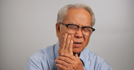 Asian elderly man suffering from toothache.