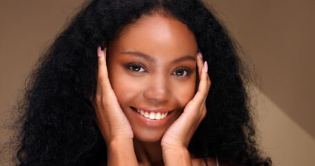 Portrait of a black girl with curly hair, soft makeup and perfect skin. Beautiful face of young black woman with natural skin.