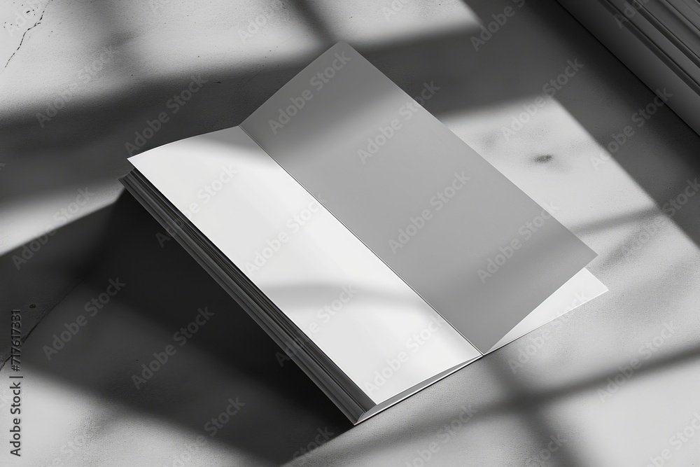 Poster A white book sits on top of a table next to a window. This versatile image can be used for various themes and concepts