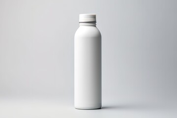 An empty white bottle in the photo on a white table and in front of a gray wall - obrazy, fototapety, plakaty