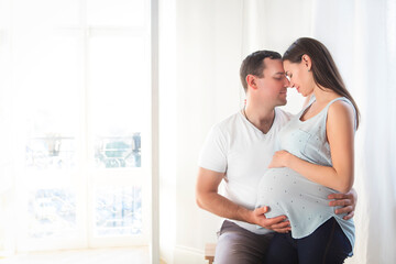 Pregnant woman and young man together indoors