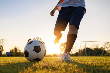 Close up shot of soccer player kicking ball. Action sport outdoors playing football for exercise at...